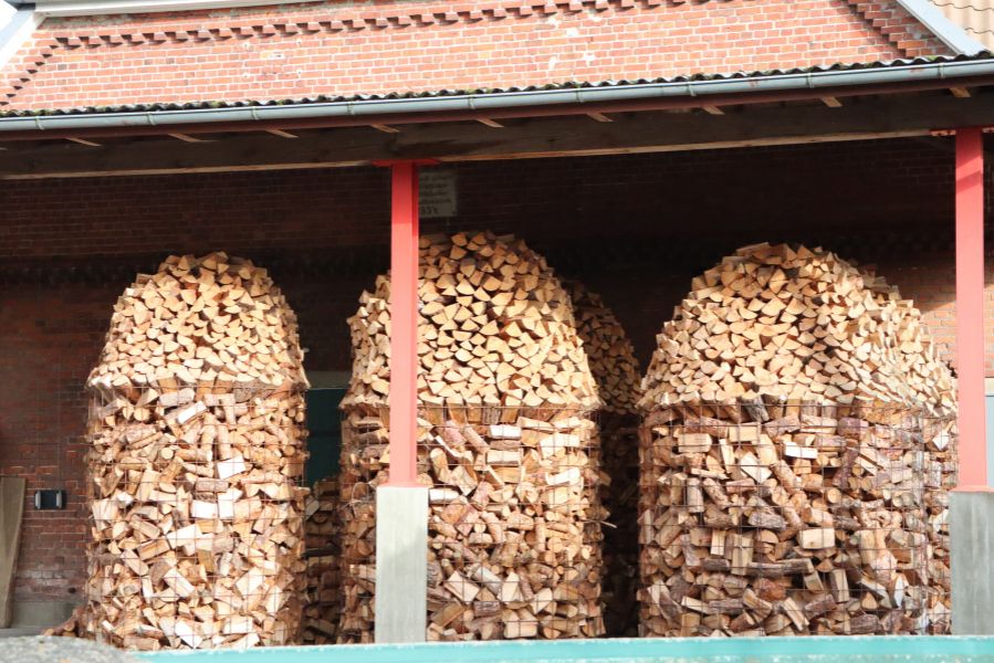 Bûches de bois empilées sous un abri extérieur pour un stockage protégé de l’humidité